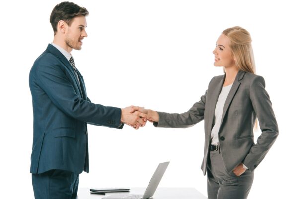 executive businesspeople shaking hands and having deal at workplace with laptop, isolated on white